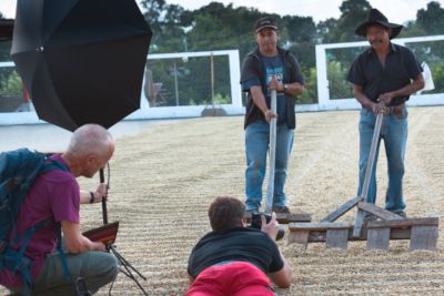 Franz Bamert hält den Blitz während Yannick auf dem Bauch liegend Kaffeebauern in Guatemala fotografiert.